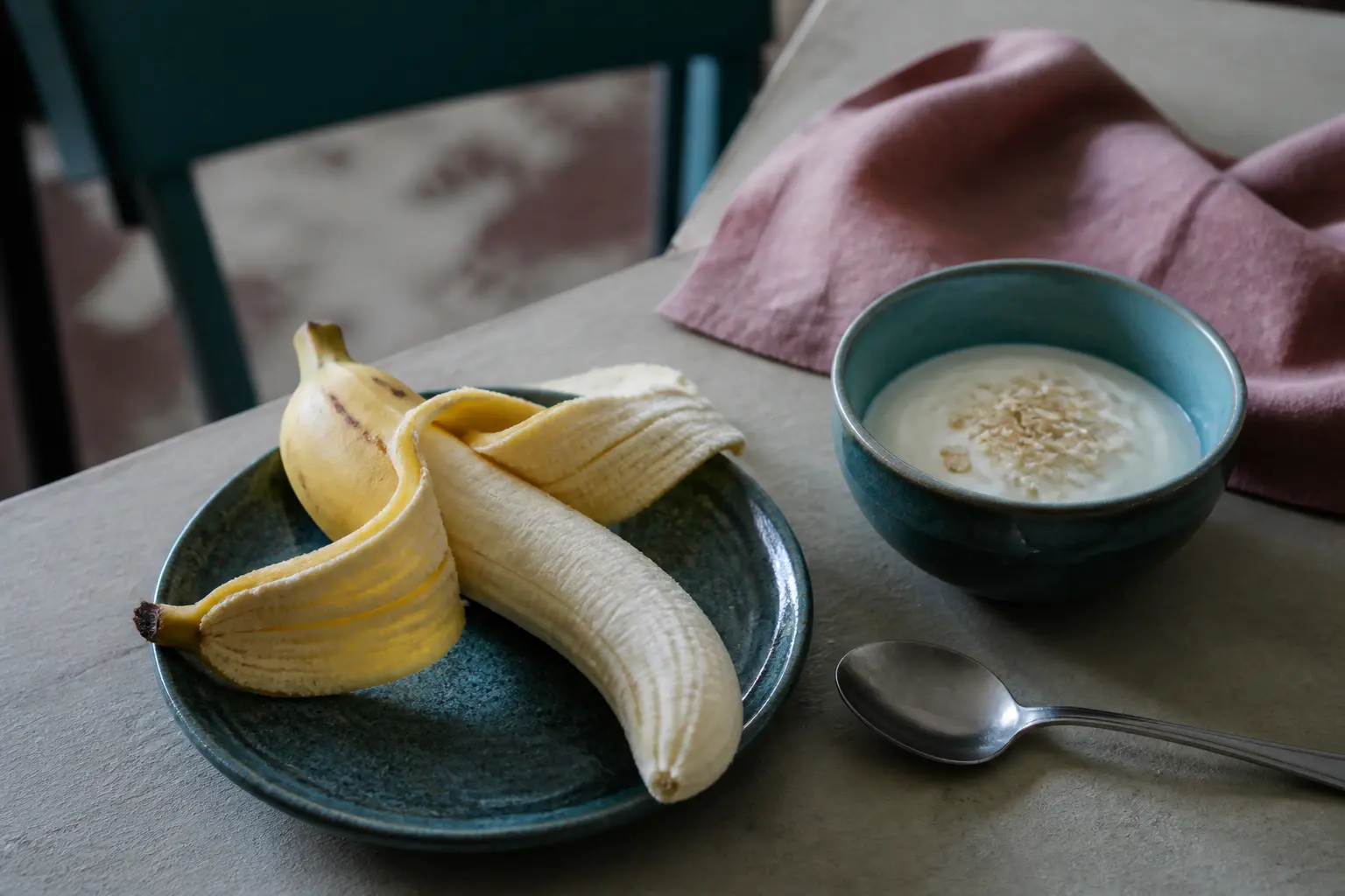 Banane et calcul biliaire : banane pelée, yaourt nature et flocons d’avoine sur table de cuisine lumineuse