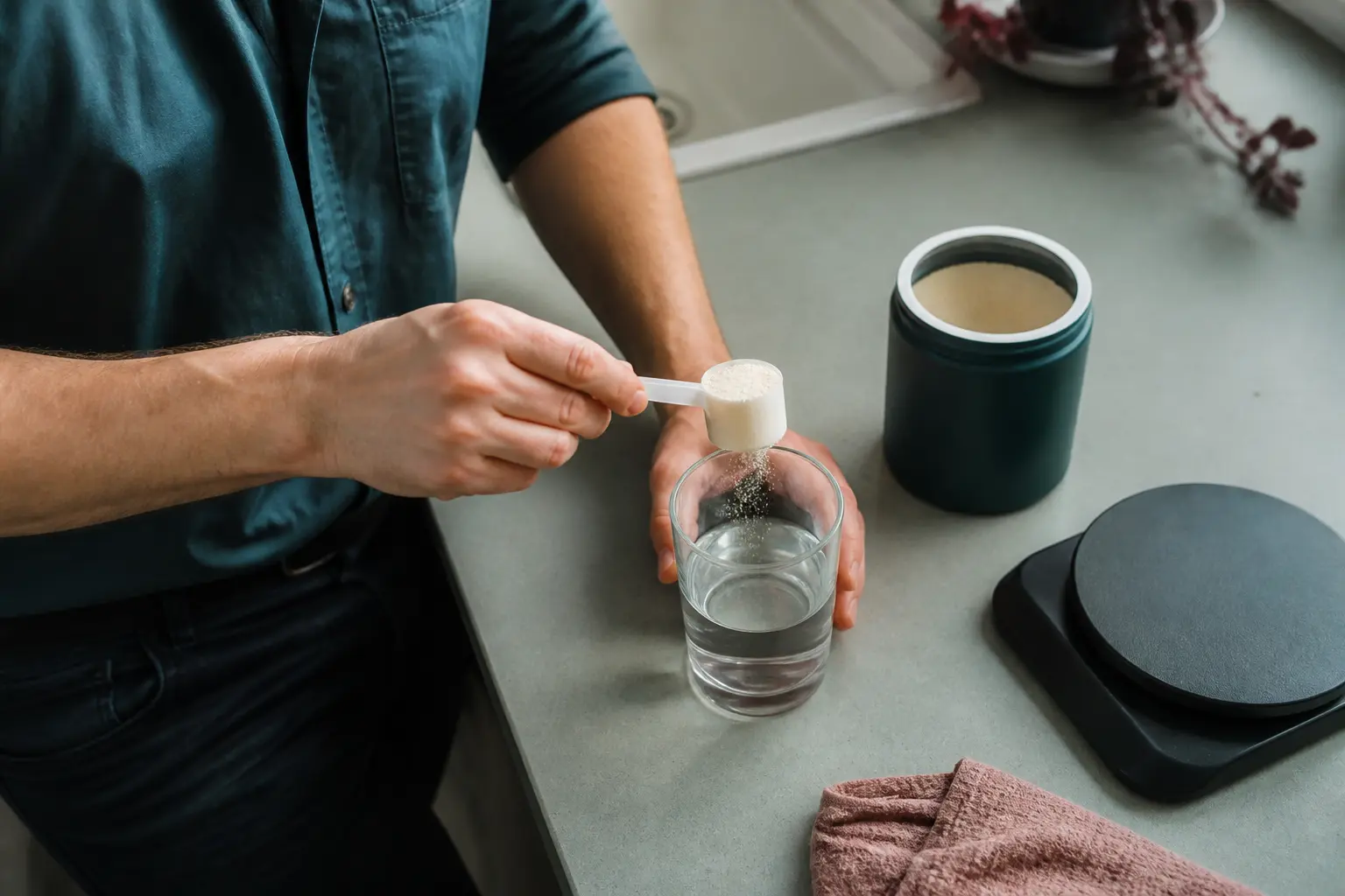 holy energy danger : mains dosant une poudre d’énergie dans une cuisine, verre d’eau et balance à côté, lumière naturelle douce