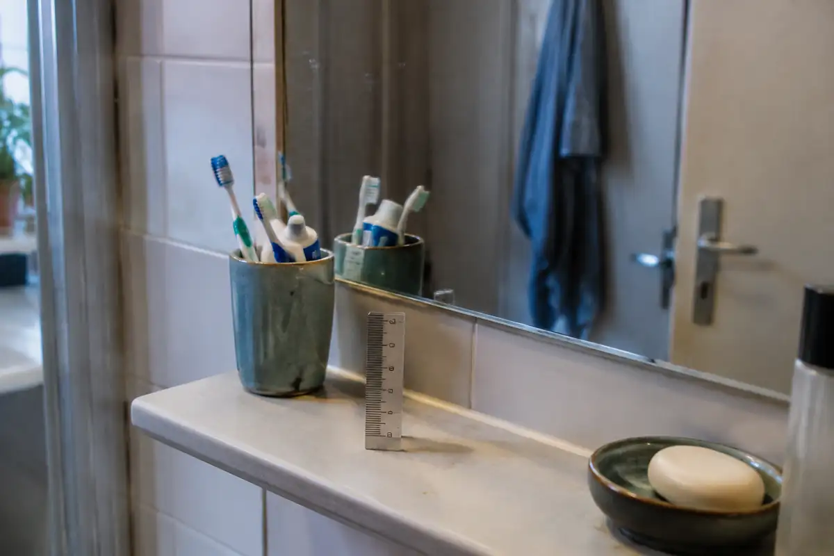Miroir de salle de bain et petite règle graduée posés sur une tablette